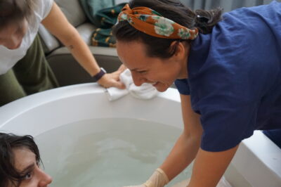 Certified-nurse-midwife-with-laboring-woman-in-tub-at-birth-center