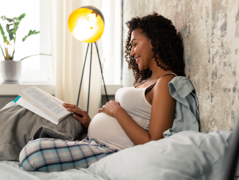 pregnant-woman-reading-on-her-bed