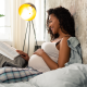 pregnant-woman-reading-on-her-bed