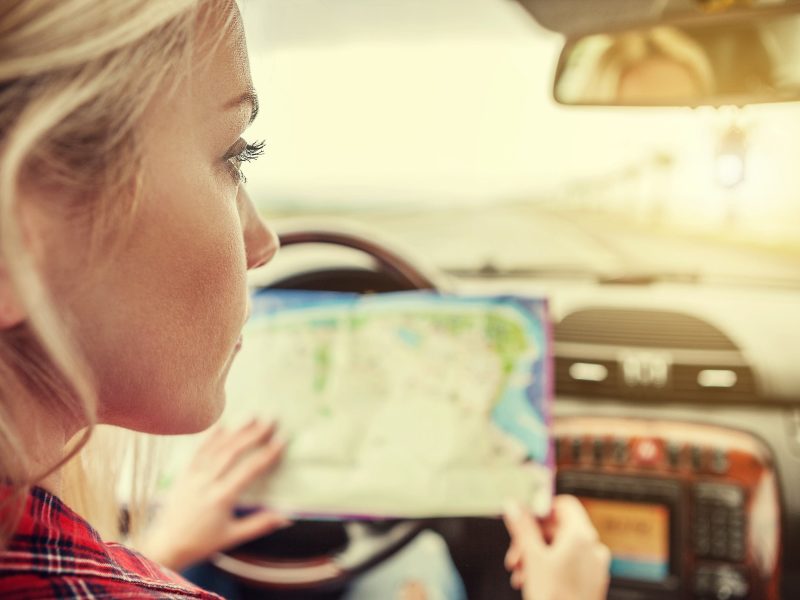 Girl in car with roads map