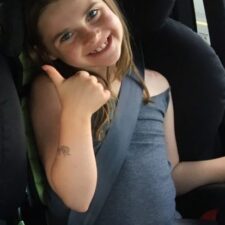 Child giving a thumbs up on a long road trip