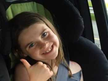 Child giving a thumbs up on a long road trip