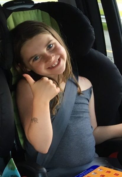 Child giving a thumbs up on a long road trip
