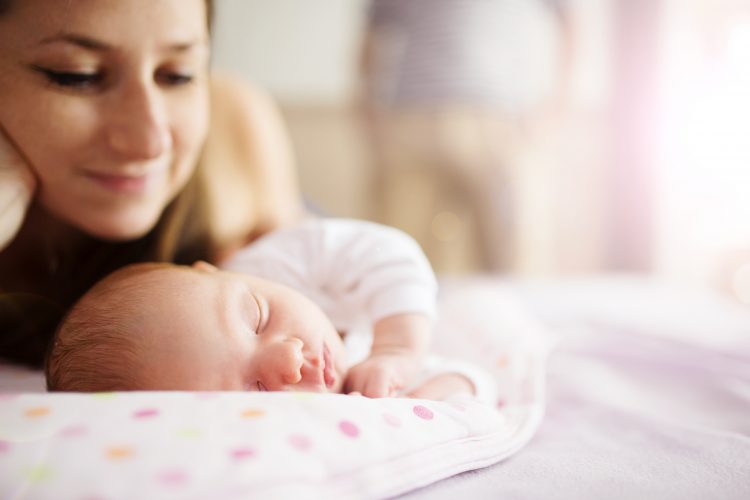 Mom gazing at sleeping newborn