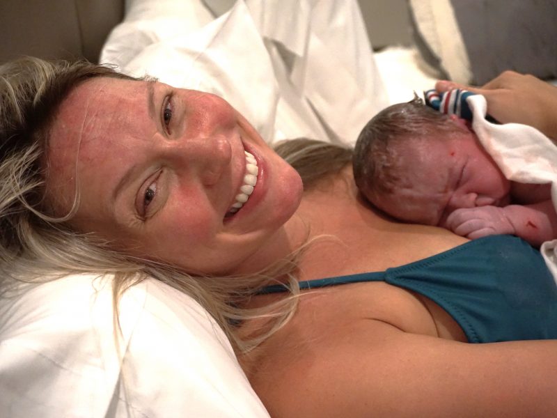 midwives-of-nj-postpartum-client-at-our-birthing-center-smiling-holding-newborn-baby