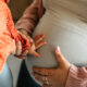 Cute Baby Girl Touching Pregnant Belly of her Mother