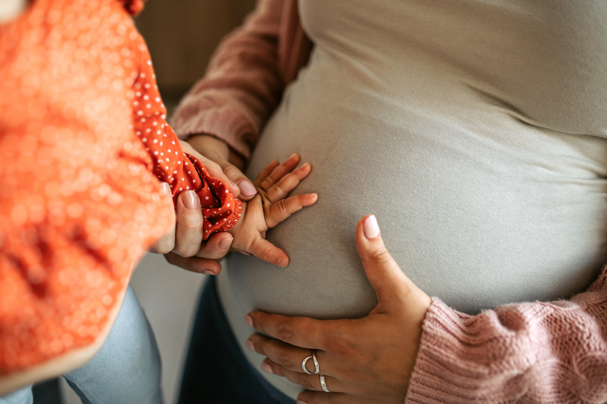 Cute Baby Girl Touching Pregnant Belly of her Mother