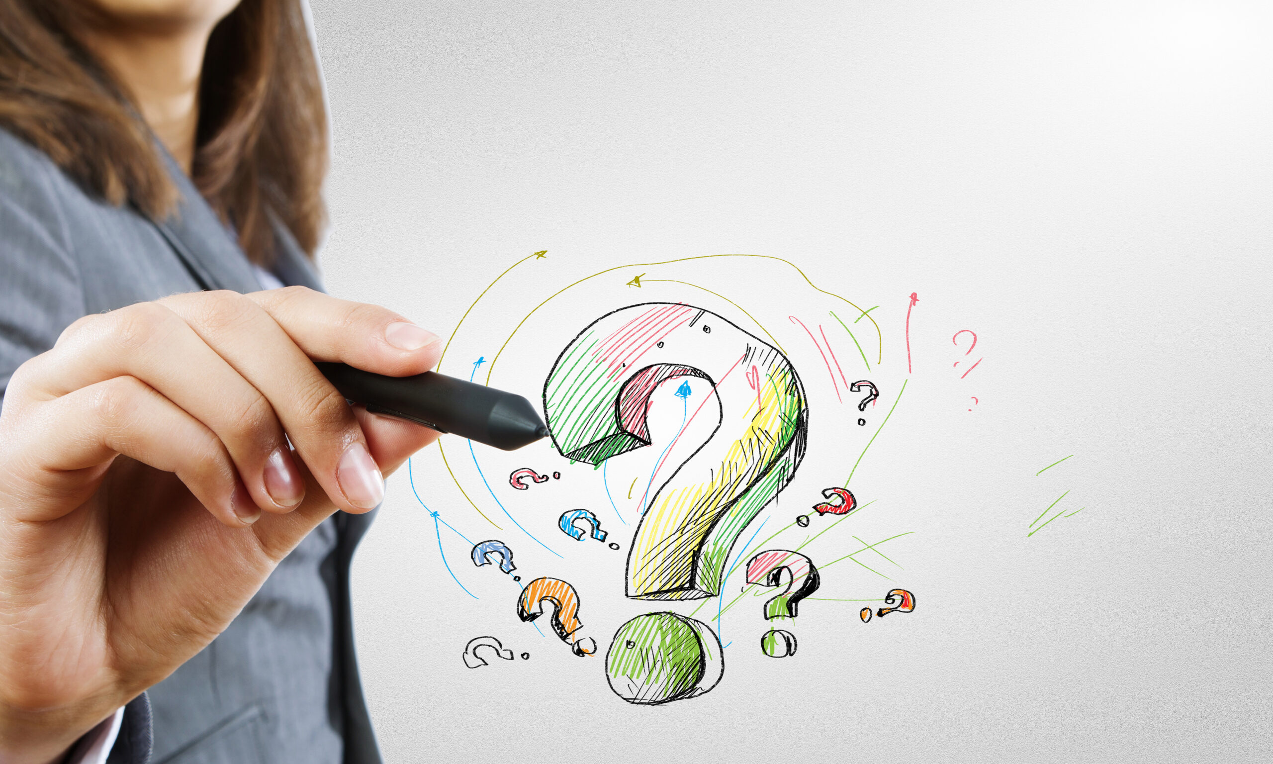 Close up of business woman drawing question mark
