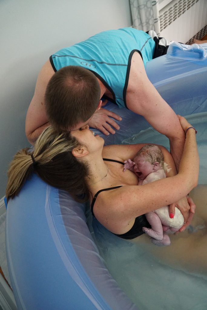 couple kissing after baby born at home waterbirth