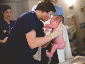 midwife holding newborn baby