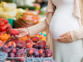 pregnant woman shopping for fruit