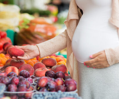 pregnant woman shopping for fruit