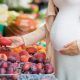 pregnant woman shopping for fruit