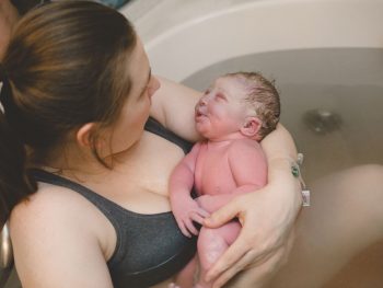 woman holding her newborn baby after waterbirth delivery